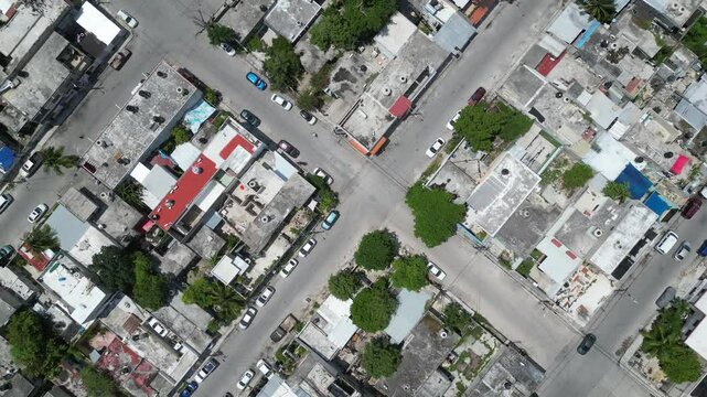 Aerial top-down view high altitude of slum, a heavily populated urban informal settlement characterised by substandard housing and squalor poor living conditions streets and rusty metal home roof tops