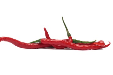 A bunch of red chili peppers are arranged on a white background. The chilies are long and slender, with a glossy appearance. They are slightly curved and have a green stem.