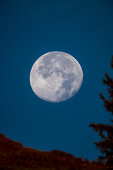 at sunrise on the mountains and the super full moon goes down, at a autumn morning