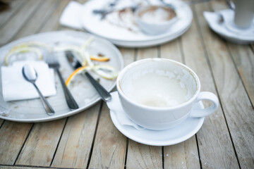 Dirty plate with food leftovers and fork on wooden background at cafe in Ojcow National Park Poland. High quality photo