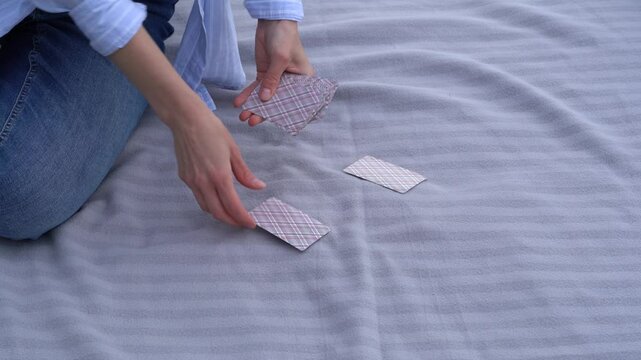 Hands of a young woman dealing classic cards from a deck to players for a beach game. The concept of board card games, having fun, entertainment, poker, solitaire