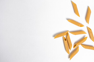 Uncooked Penne Pasta on White Background