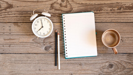 Notebook on a wooden background, spiral notepad and coffee on a table