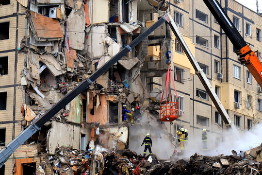 Russian missile strike destroyed residential building, Dnipro, Ukraine. Rescuers are looking for people under rubble of house, rescue equipment, fire. Russian war
