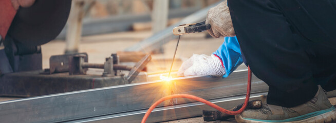 Banner Men hands wear protective glove Hot flame metal work cut fire iron workshop. Locksmith cut...