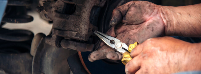Banner Close up Mechanic man hands repairing car auto repair shop. Banner Man hands fixing machinery check vehicle mechanical motor service. Vehicle Car overhaul maintenance engineer with copy space