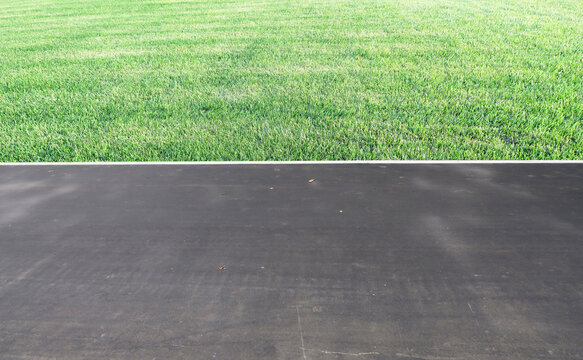 aying of sidewalks with new asphalt. Curbs enclosing the lawn, grass