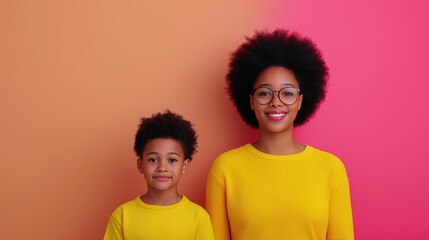 Fototapeta premium Mother and son smiling against colorful background in yellow outfits