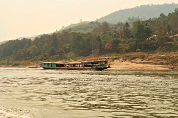 On the slow boat from Thailand to Laos, passing another slow boat on the Mekong River, Laos