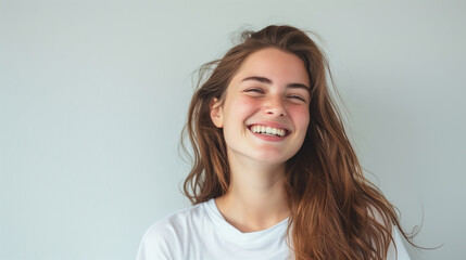 Naklejka premium Smiling Woman in White T-Shirt Against Minimalist Background