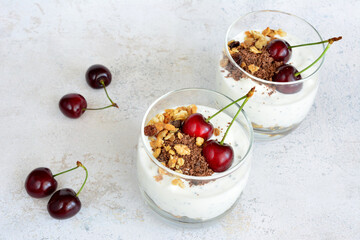 healthy breakfast with oatmeal, yogurt, bitter chocolate and cherries in a drinking glass 