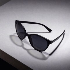 a monochromatic studio shot of the total black sunglasses on a medium gray background. Use soft lighting to ensure the sunglasses blend seamlessly with the background, while subtly highlighting their