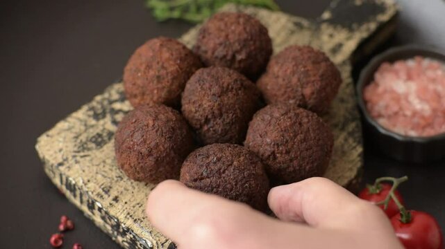 Falafel vegetarian and vegan dish made with chickpeas, spices and herbs on a dark concrete background