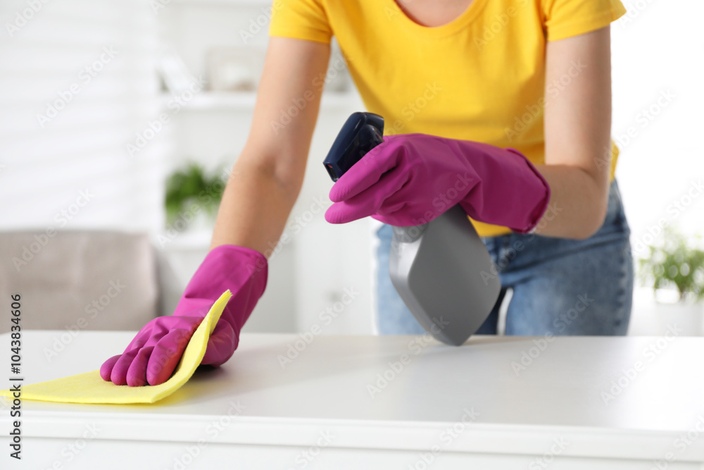 Sticker Young woman cleaning table with rag and spray in office, closeup