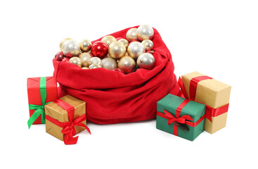 Red Santa Claus bag with baubles and gift boxes isolated on white
