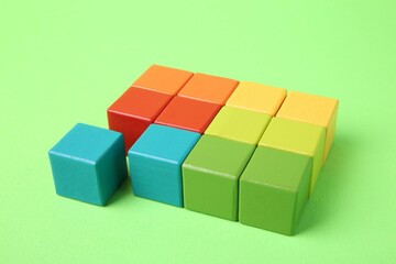Obraz premium Many wooden colorful cubes on green background