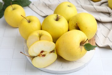 Fresh ripe yellow apples on white tiled table