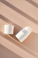 Roll-on deodorant on a purple background with shadow stripes.