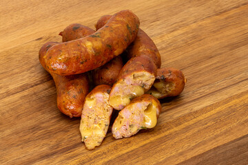Delicious Grilled Sausages with Cheddar Chunks beautifully arranged on a Wooden Board