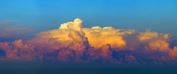 Bright sunset with setting sun behind vivid orange and yellow clouds