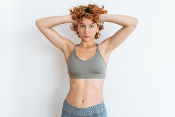 Portrait of a young woman with an athletic build, wearing a sports top, showing off her muscular...