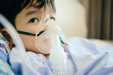 Boy 4 years old , inhale medication by inhalation mask to cure Respiratory Syncytial Virus (RSV) on...