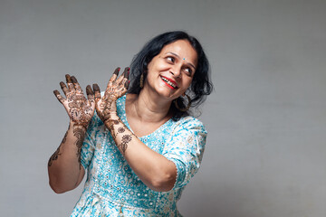 A joyful Indian woman showcasing her beautiful henna design, captured during the Karva Chauth...