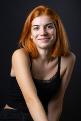 Fototapeta premium Cute red-haired girl, studio portrait on a black background.