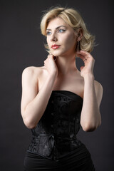 Fototapeta premium Expressive young blonde under a bob in the studio. In a black corset and dress.