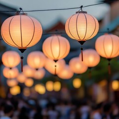 Close-up of glowing lanterns hanging above a festival parade, casting soft light onto the crowd