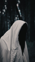 person in white cloak in the woods
