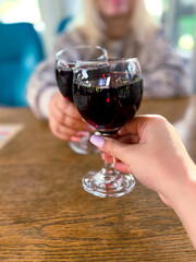 Women drink red wine from glasses. Women couple celebrating with red wine