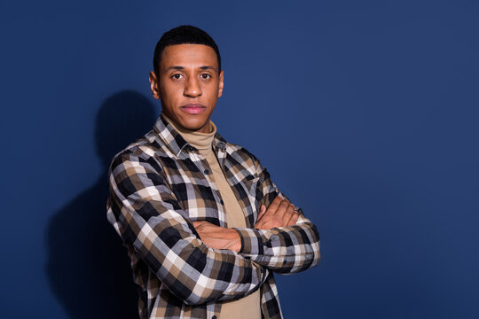 Photo of serious cinfident guy dressed plaid shirt hands crossed emtpy space isolated blue color background
