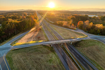 Freeway overpass junction with fast moving traffic cars and trucks in American rural area at...