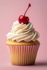Delicious vanilla cupcake topped with cream frosting and a cherry on pink background