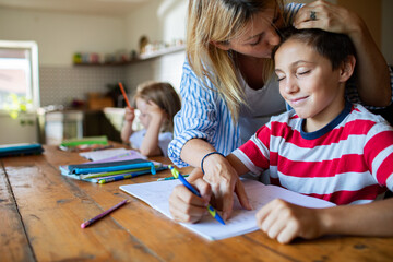 Mother helping son with homework at home