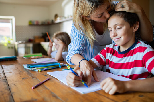 Mother helping son with homework at home