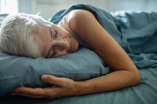 Close up of a senior woman comfortably sleeping in her bed