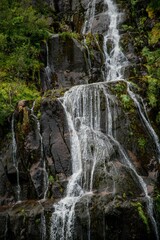 Obraz premium Cascading waterfall over dark rocks