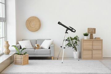 Interior of living room with grey sofa and modern telescope