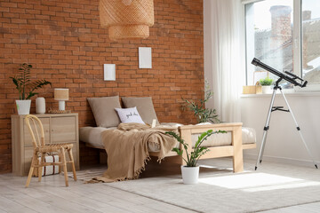 Interior of bedroom with cozy bed and modern telescope near window
