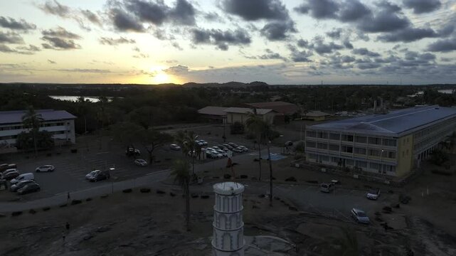 Drone flies backwards over Dreyfus Tower facing sunset in Kourou, French Guiana, France