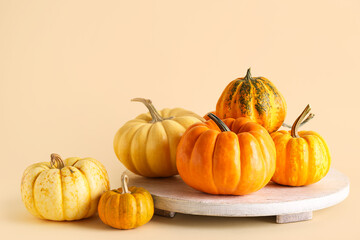 White board with fresh pumpkins on beige background