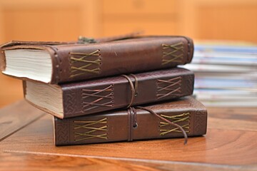 leather bound notebooks on a wooden table
