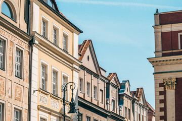 Fototapeta premium Colorful Historic Buildings and Houses on Stary Rynek Square in Poznań, Poland, with a Blue Sky and Mural Art