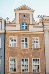 Colorful Historic Buildings and Houses on Stary Rynek Square in Poznań, Poland, with a Blue Sky and Mural Art © explorateurphotos
