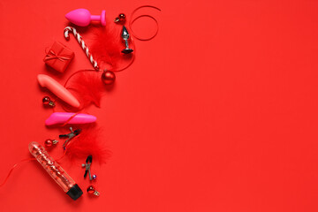 Composition with sex toys and Christmas decorations on red background