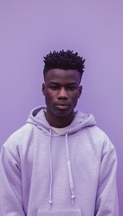 Fototapeta premium Young Man in Light Grey Hoodie Against Lavender Background for Calm and Relaxed Portrait Design