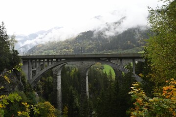 Scenic stone arch bridge in misty mountains