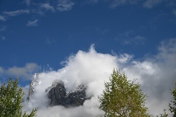 Mountain peak with clouds and blue sky.